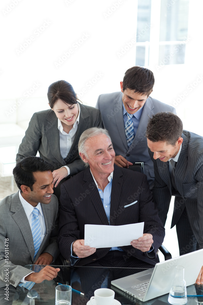 Senior manager showing sales report to his colleagues Senior manager showing sales report to his colleagues