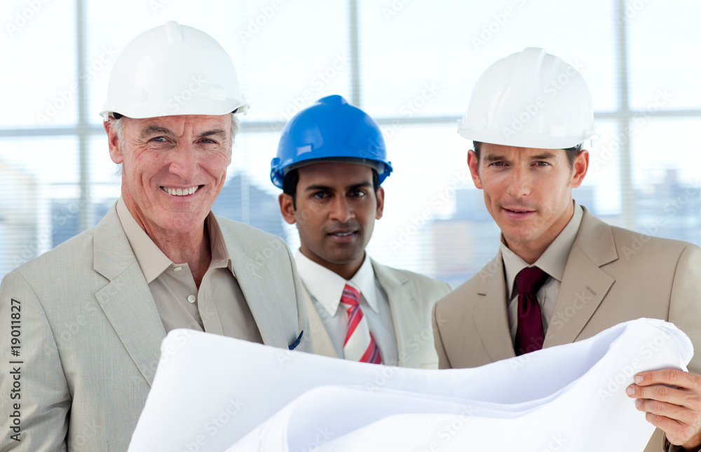 Smiling architects studying blueprints Smiling architects studying blueprints