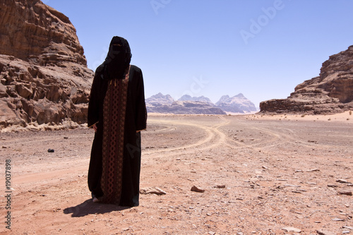 Bedouin woman with burka in desert photo