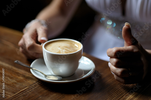 Bride s hands holding cup of coffe