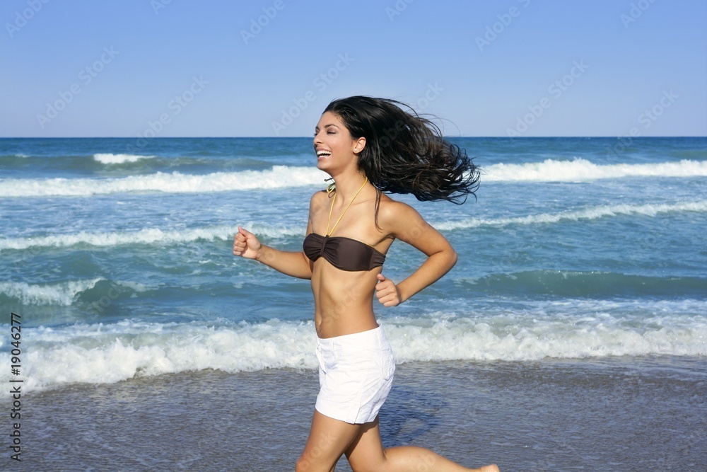 Beautiful summer brunette girl jumping on the beach Beautiful summer brunette girl jumping on the beach