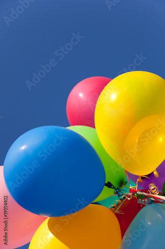 Multi colored balloons with a sky background