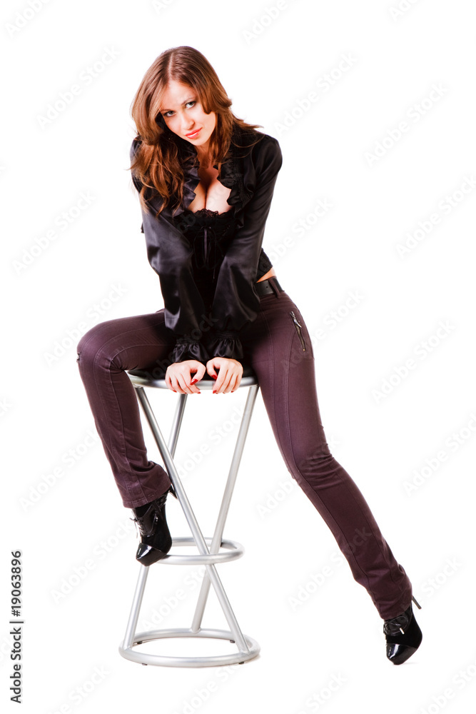 Fototapeta premium Young alluring girl in black on chair