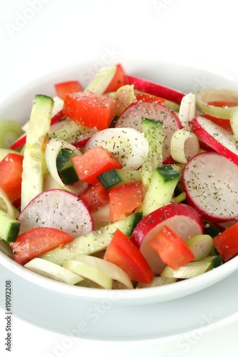 Fresh salad with tomato, cucumber, radish and spring onion