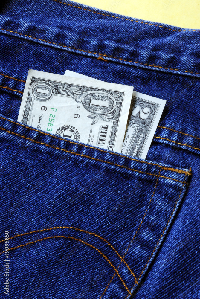 Money in the rear pocket of a blue jeans isolated on yellow Money in the rear pocket of a blue jeans isolated on yellow