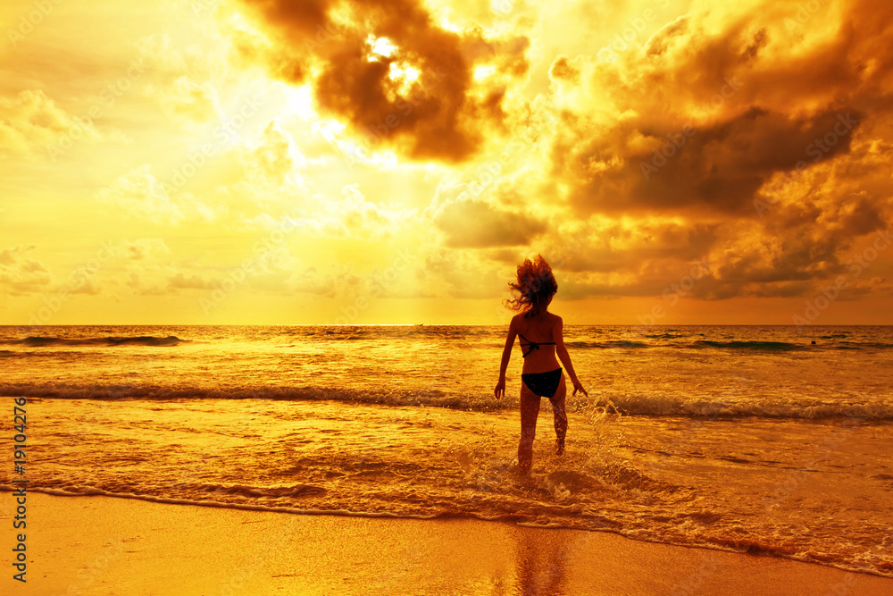 The runnig girl on a tropical beach