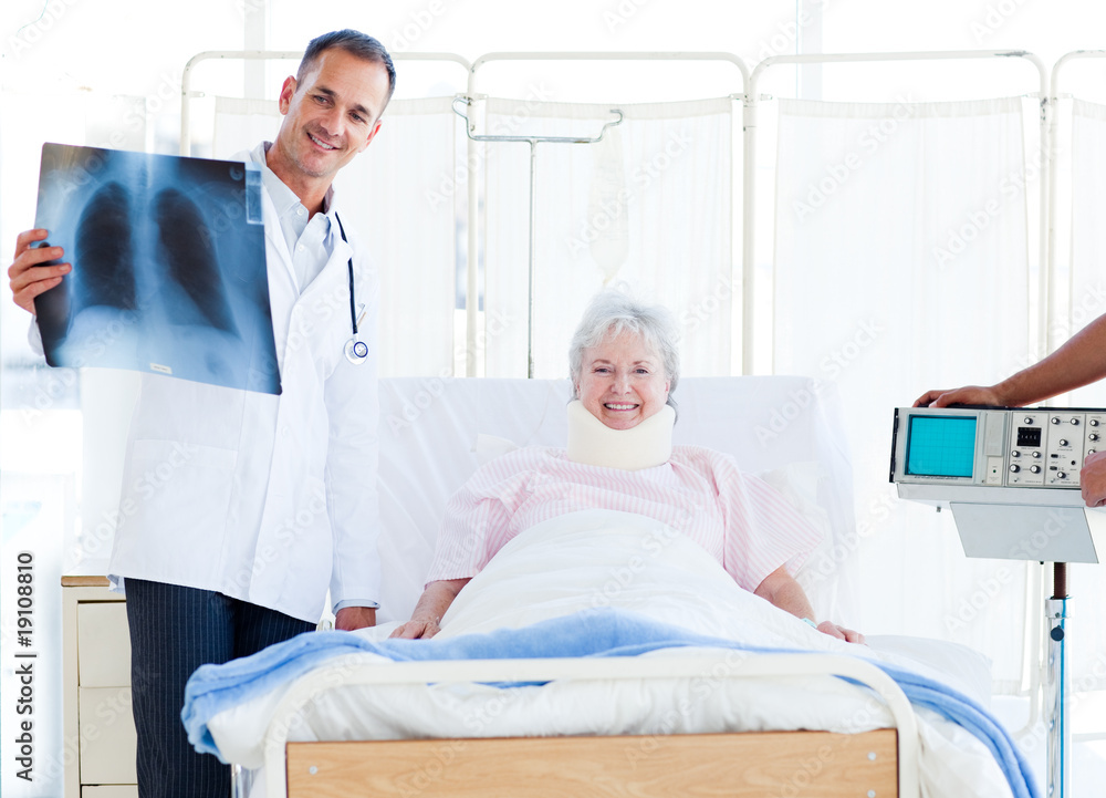 A patient with a neck brace looking at an x-ray with her doctor A patient with a neck brace looking at an x-ray with her doctor