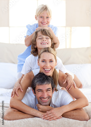 Happy family having fun on a bed