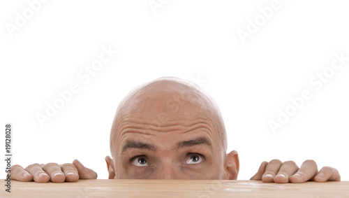 Mann schaut über Tischkante