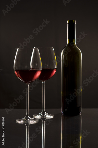Two glasses red wine and one bottle