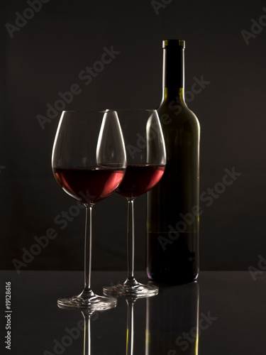 Two glasses red wine and one bottle