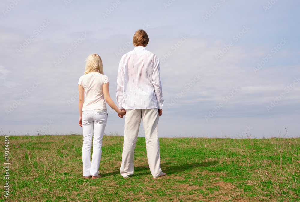 Guy and girl standing on the green meadow Guy and girl standing on the green meadow