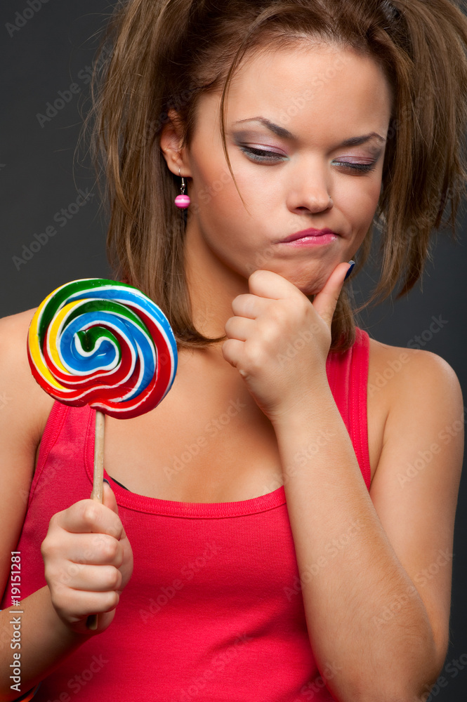 thoughtful funny girl with lollipop