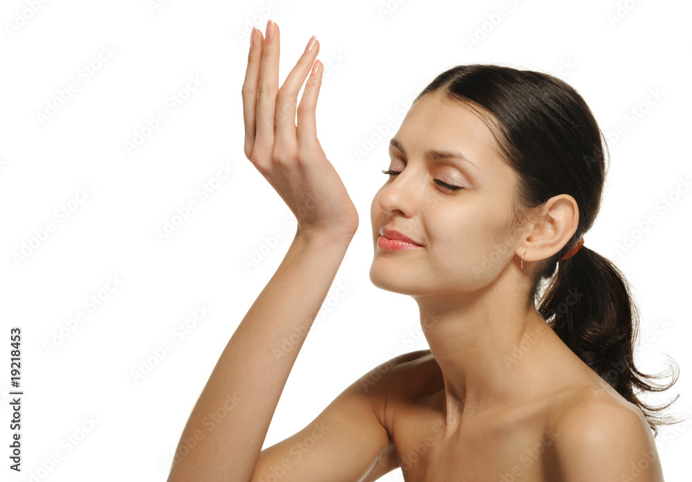 The pretty woman enjoying aroma of perfume. It is isolated on a The pretty woman enjoying aroma of perfume. It is isolated on a