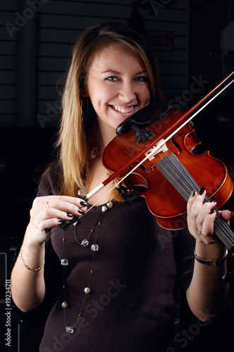 young female play on violin in music study