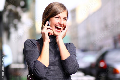 Happy young lady talking on mobile phone © Andrey_Arkusha