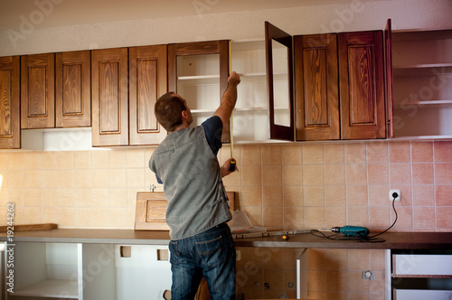 Carpenter working on new kitchen cabinets photo