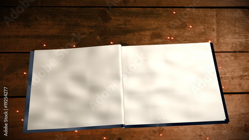 Open book with blank pages on wood table with magic sparkles