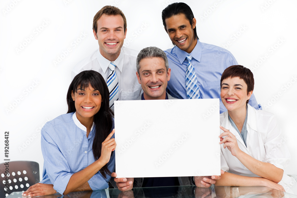 A business group showing diversity holding a white card A business group showing diversity holding a white card