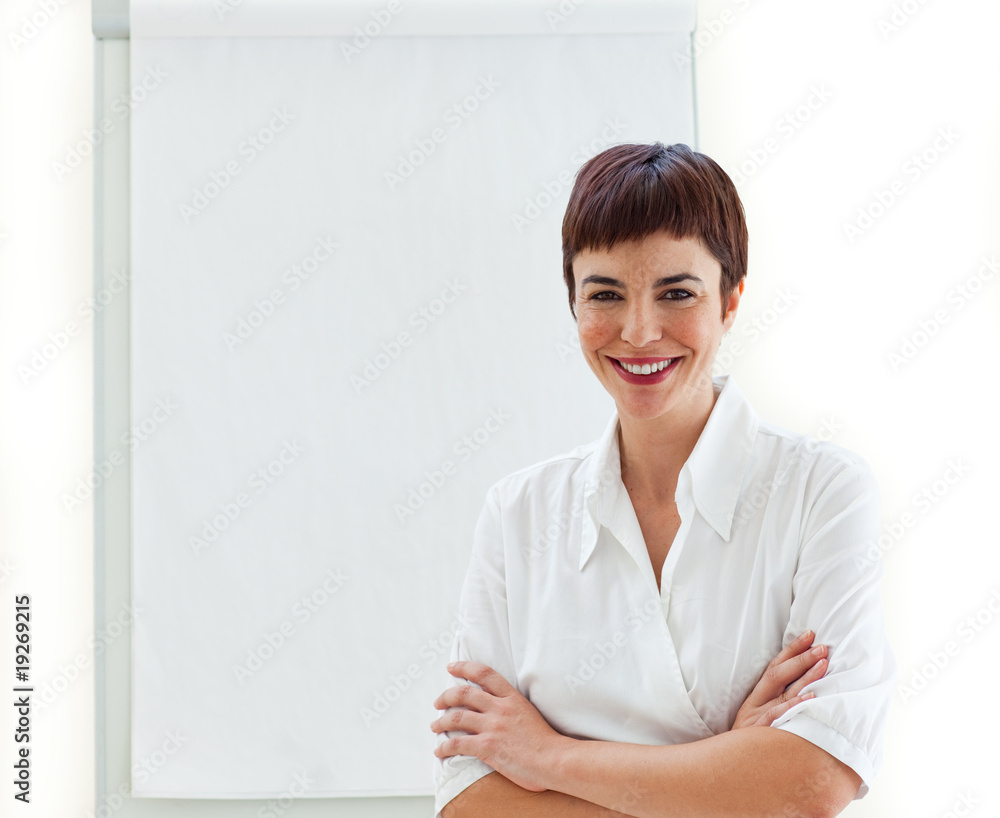 Young businesswoman with folded arms in front of a board Young businesswoman with folded arms in front of a board