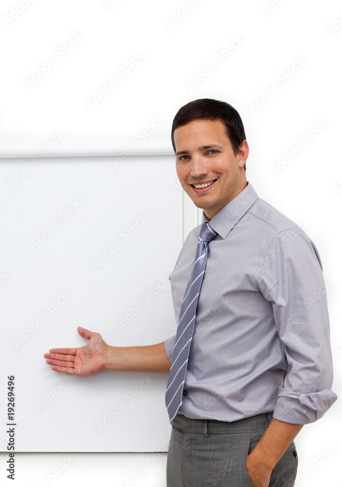 Assertive young businessman pointing at a board Assertive young businessman pointing at a board