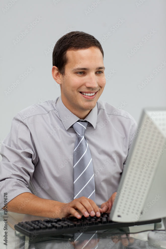 Charming young businessman working at a computer Charming young businessman working at a computer