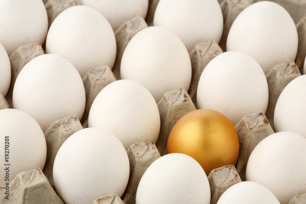 Gold egg among white in cardboard container Gold egg among white in cardboard container