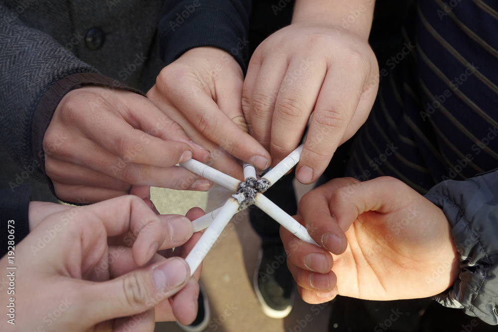 six hands of teens with cigarettes close by six hands of teens with cigarettes close by