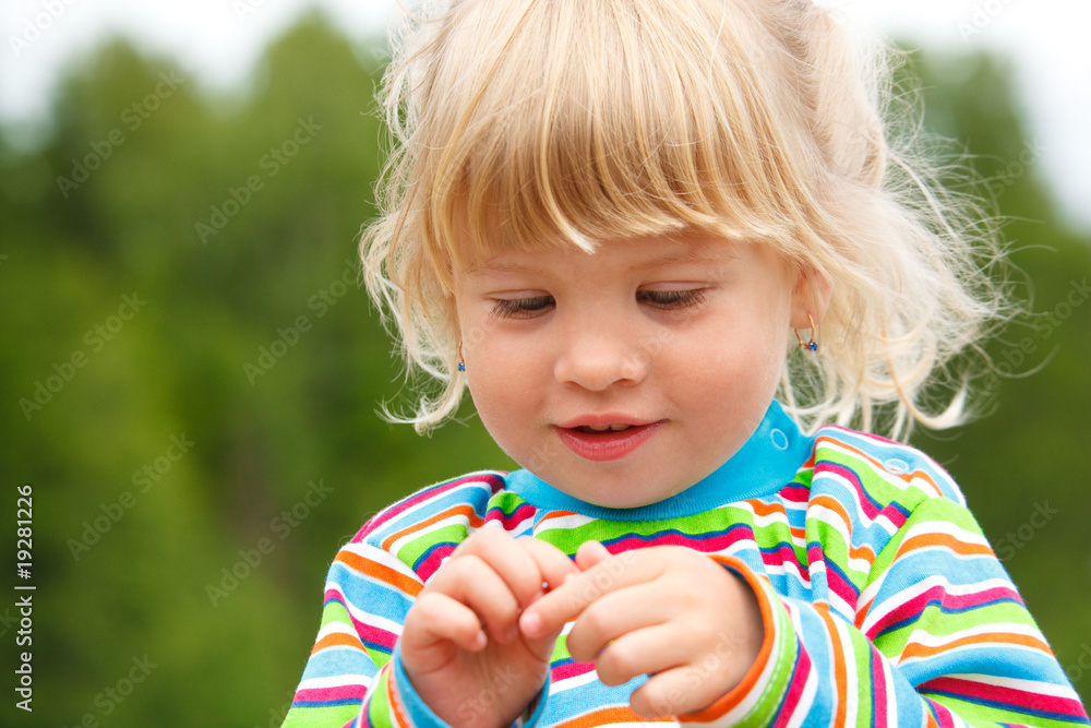 Portrait of little girl in stripe clothe with earrings in park. Portrait of little girl in stripe clothe with earrings in park.