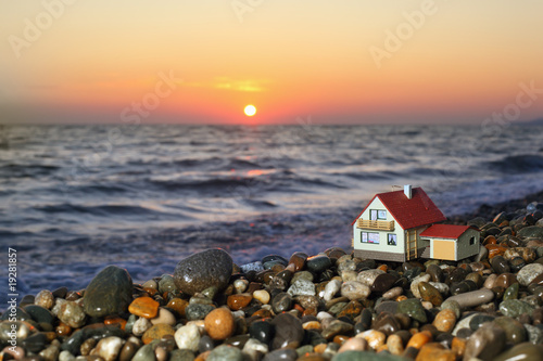 model of house with garage on stony beach in evening