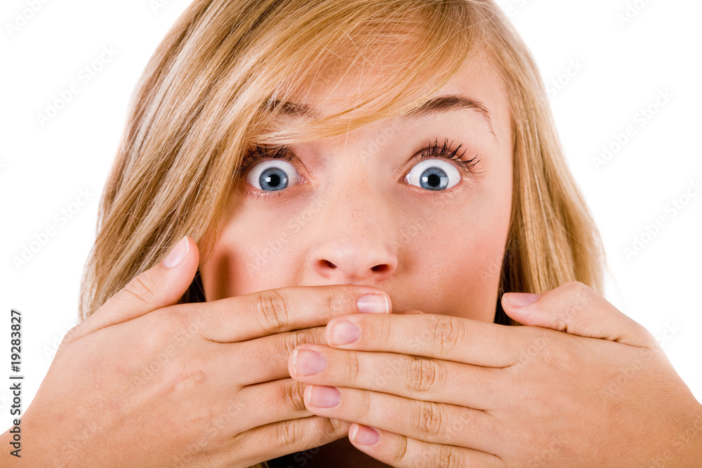 Closeup of young women covering her mouth with both hands Closeup of young women covering her mouth with both hands