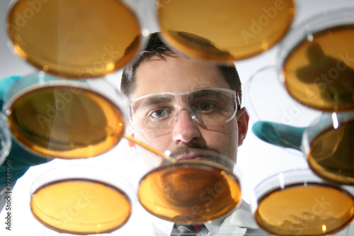 Mann mit Petrischalen in besonderer Perspektive.