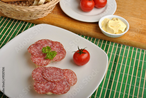 Fotografía slice poppy seed bread with salami on a plate