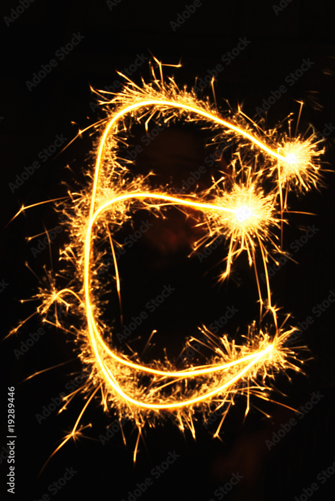 Letter E made of sparklers isolated on black