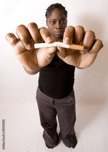 jeune femme noire tord une cigarette entre ses doigts photo