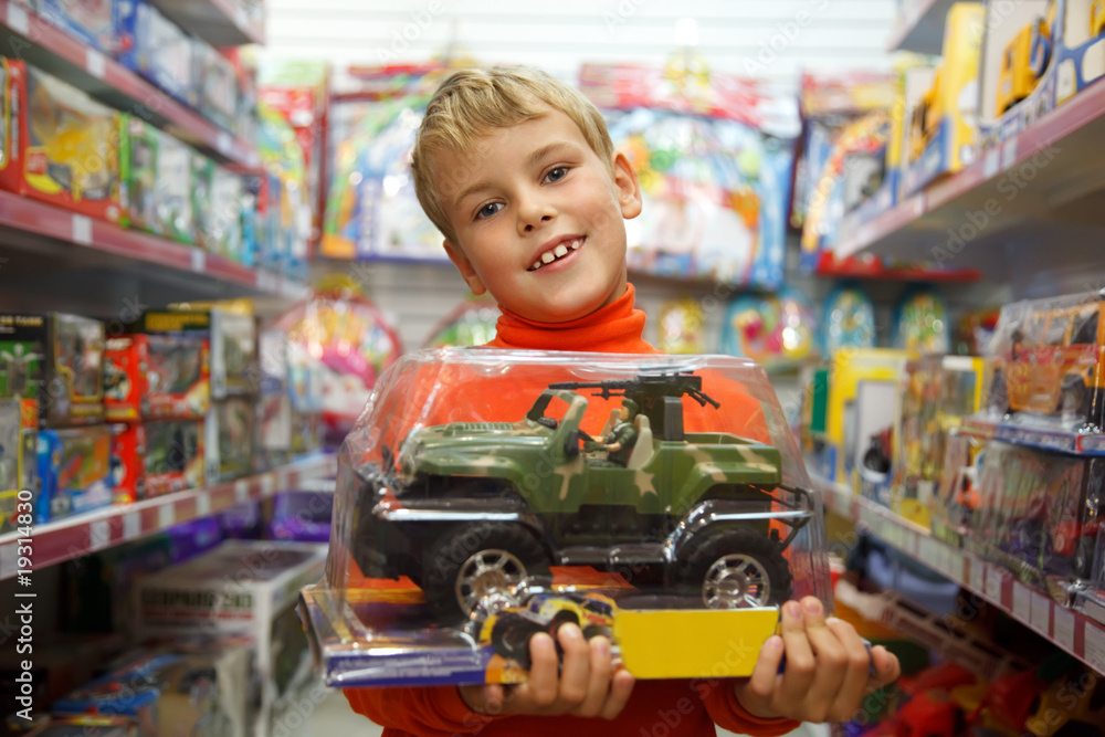 The boy in shop with the toy machine in hands Stock Photo | Adobe Stock