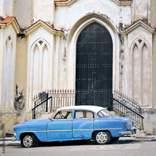 Old car in havana building facade © roxxyphotos