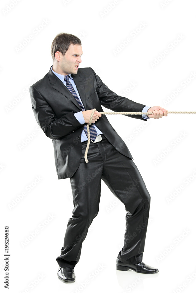 A young businessman pulling a rope isolated on white A young businessman pulling a rope isolated on white