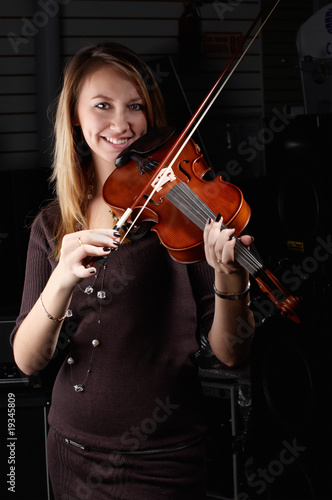 young female play on violin in music study