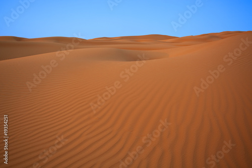 desert dunes right before sunset with blue sky