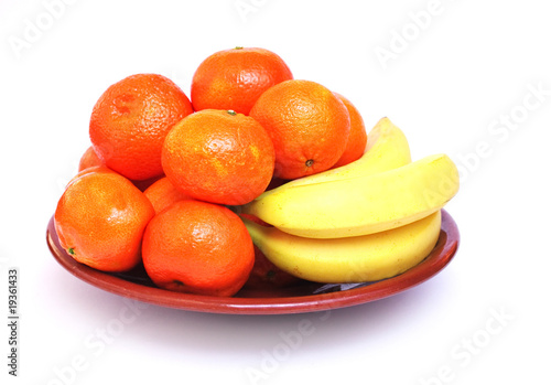 Tangerines and bananas on plate