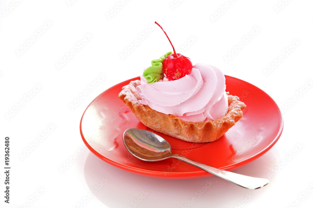 Pink cheesecake with maraschino cherry on white Pink cheesecake with maraschino cherry on white