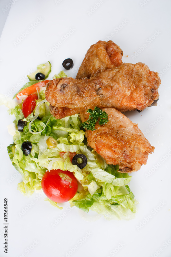 Roasted chicken legs with salad.