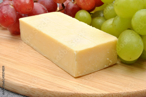 cheese and sweet grape on a timber board