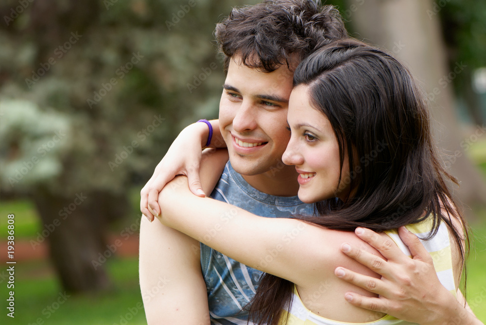 Fototapeta premium couple portrait outdoors smiling with a green background