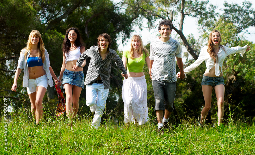 Youth group running on a grass against the nature Youth group running on a grass against the nature