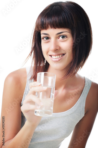 Beautiful smiling young woman holding a glass of water