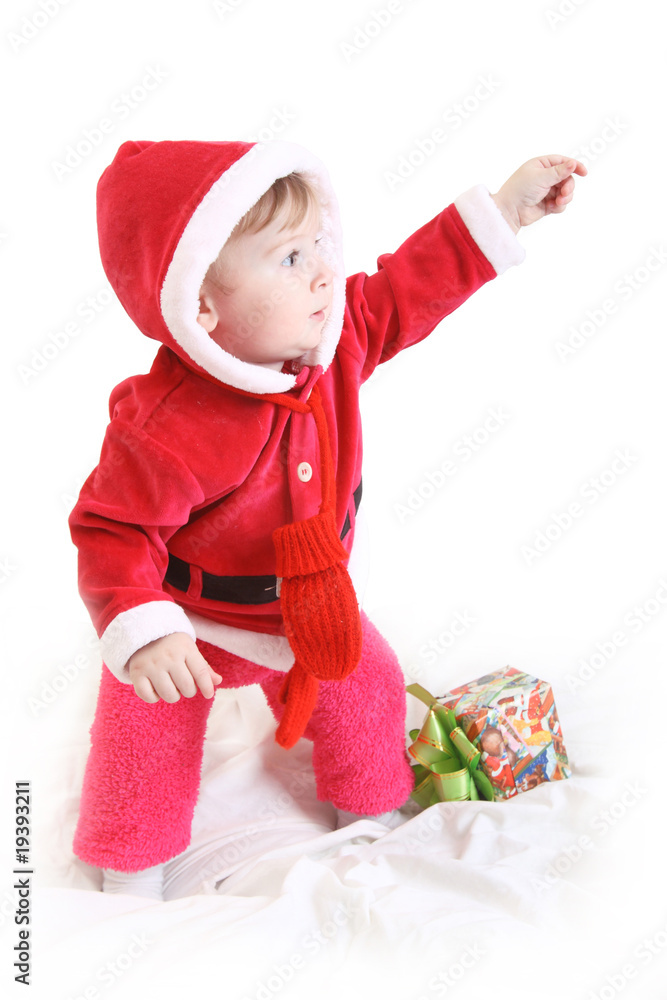 Little girl in santa's clothes with present