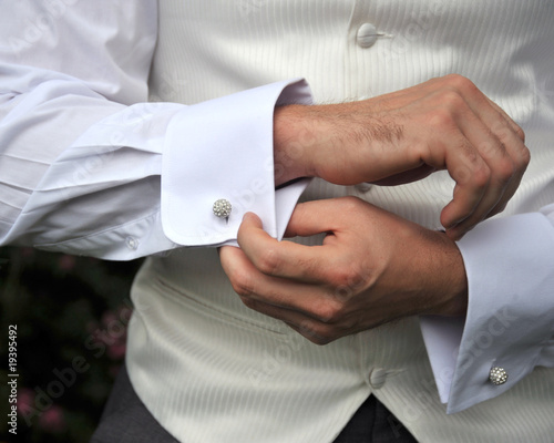 Groom checking cufflinks