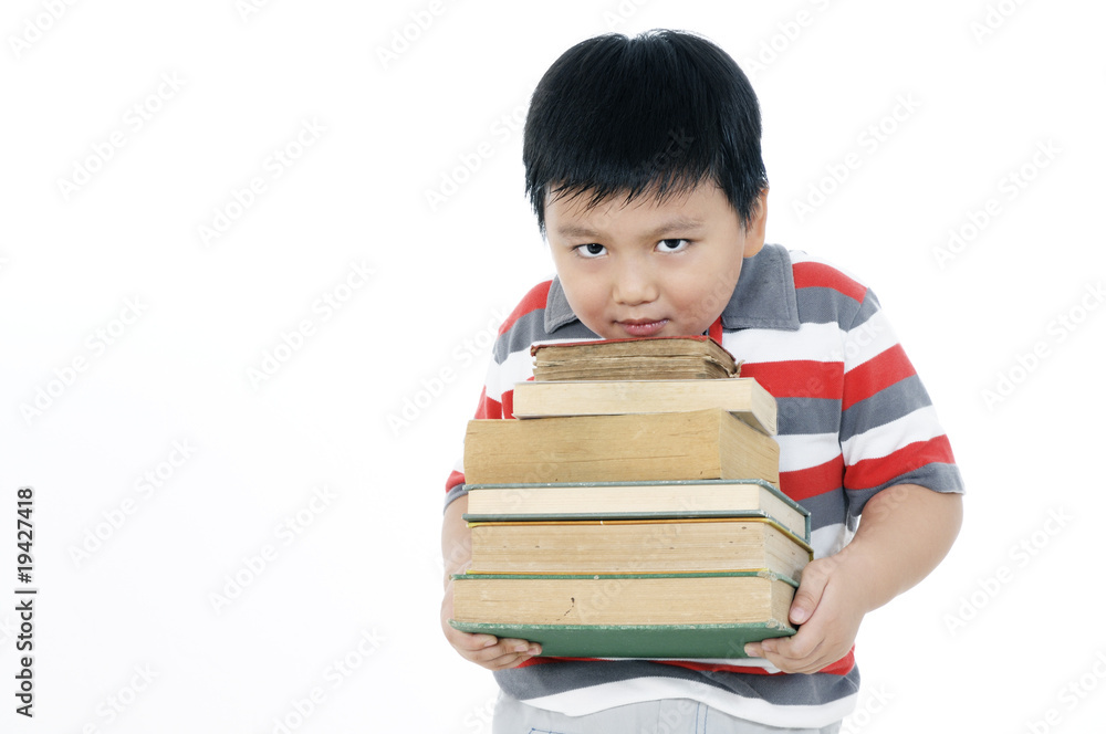 Elementary schoolboy carrying a heavy pile of books Elementary schoolboy carrying a heavy pile of books